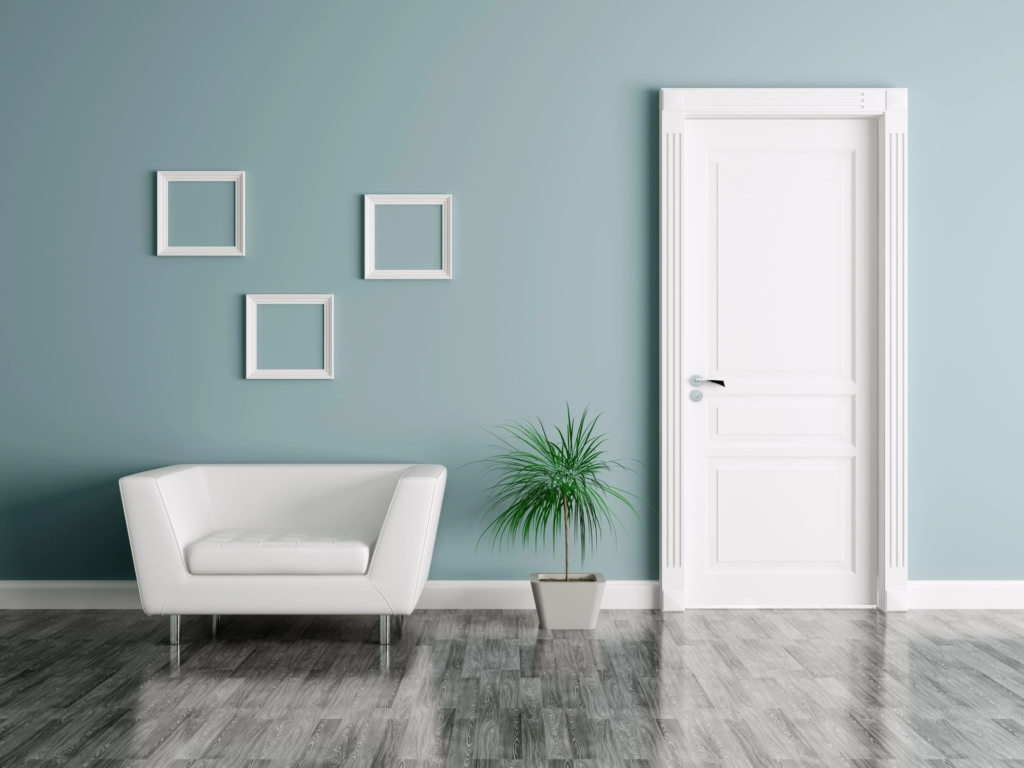 Entry way with a couch, wall frames, a plant, and door